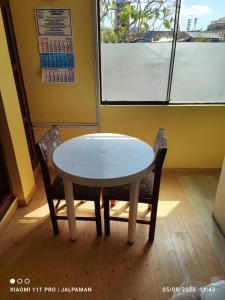 una mesa blanca y 2 sillas en una habitación en C&B APARTAMENTOS, en Jauja