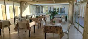 an empty restaurant with tables and chairs and windows at Bagno Luciano in Marina di Carrara