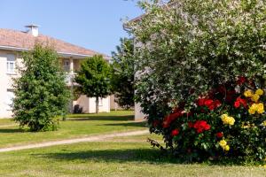 uma casa com um arbusto de flores no quintal em Patio Parc Résidence em Argenton lʼÉglise