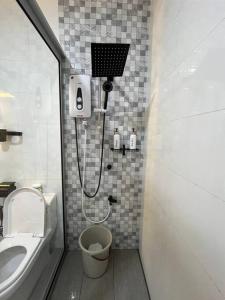 a bathroom with a shower and a toilet and a sink at Homestay Tawau With Seaview. Anekayangan Homestay in Tawau