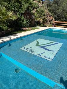 una piscina con una señal en el medio. en Cabañas Villa Luz en Salsipuedes