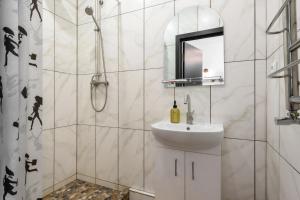a white bathroom with a sink and a mirror at Апартаменти в історичному центрі міста Чернівці in Chernivtsi