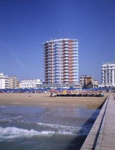 una spiaggia con alti edifici sullo sfondo e l'oceano di Hotel Caravelle&MiniCaravelle a Lido di Jesolo