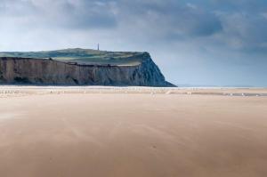 een uitzicht op een strand met een klif bij Les appartements d'Ostende in Calais