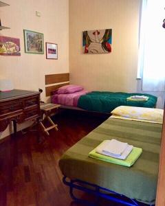 サレルノにあるCasa Vacanze Seahorseのベッド2台、テーブル、デスクが備わる客室です。