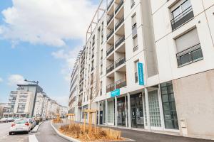 a building on a street with a car parked in front at Appart'City Classic Lyon Vaise St Cyr in Lyon