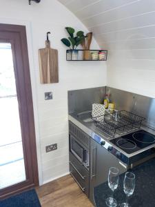 a kitchen with a stove top oven next to a window at Highland Stays - The Oaks Studio Pod in Fort William