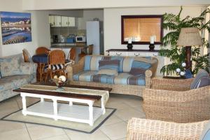 a living room with a couch and chairs and a table at Beachcastle in Stilbaai