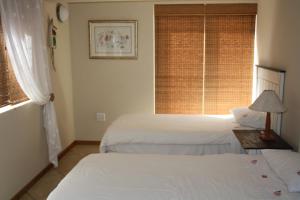 a hotel room with two beds and a window at Beachcastle in Stilbaai