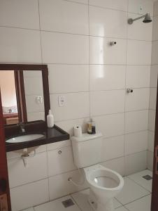 a bathroom with a toilet and a sink and a mirror at Residencial Ilha de Capri in Campina Grande