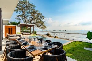 a dining table and chairs with a view of the ocean at Kove Samui in Koh Samui 