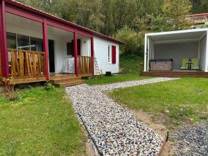 une petite maison avec une terrasse couverte et une terrasse dans l'établissement Erreka pays basque, à Hasparren