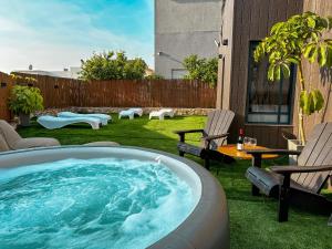 a hot tub in a yard with chairs and a table at Gilboa cliffs- Royal mountain villa in Nurit