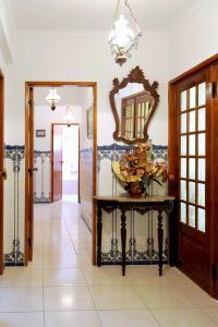 a hallway with a table and a mirror at Apartamento Vista Cidade in Figueira da Foz