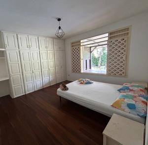 een slaapkamer met een groot bed en een raam bij La Villa des Palmiers Bleus - Piscine & Jardin in Matoury