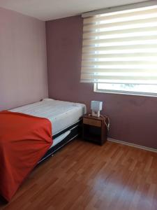 een kleine slaapkamer met een bed en een raam bij Vacaciones en viña del mar in Viña del Mar