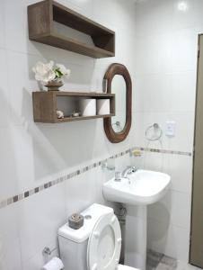 a white bathroom with a toilet and a sink at Hospedaje La Bussola I in Gualeguaychú