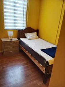 een kleine slaapkamer met een bed en een nachtkastje bij Vacaciones en viña del mar in Viña del Mar