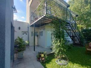a house with a garage with a staircase and a door at Hospedaje La Bussola I in Gualeguaychú