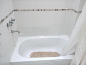 y baño con bañera y cortina de ducha. en Hospedaje La Bussola I en Gualeguaychú
