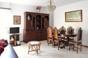 a living room with a dining room table and a tv at Apartamento Vista Cidade in Figueira da Foz