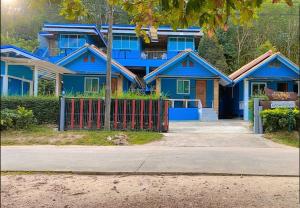 una casa azul con una valla roja delante de ella en Ban Tidlay - SHA en Ko Yao Noi