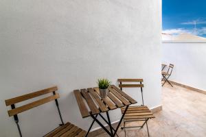 a patio with two benches and a table with a potted plant at MQ Suites Veronica in Valdepeñas