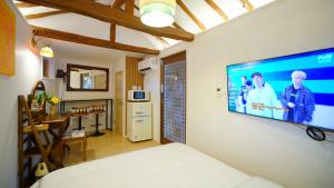 um quarto com uma televisão de ecrã plano na parede em And spring em Jeonju