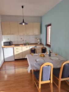 kuchnia ze stołem i krzesłami w kuchni w obiekcie Apartmani Vuković Punat w mieście Punat