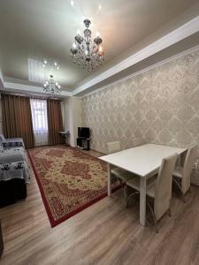 een eetkamer met een witte tafel en een kroonluchter bij apartment on st. Frunze 553 in Bisjkek