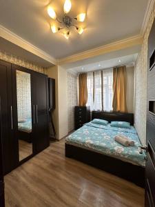 een slaapkamer met een bed en een plafondventilator bij apartment on st. Frunze 553 in Bisjkek