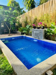 - une piscine dans une cour avec une clôture en bois dans l'établissement Likod Bahay Cabin, 