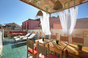 un patio con mesa y sillas en la azotea en Riad Amal, Exclusif et élégant à 6 min de Jemaa El Fna en Marrakech