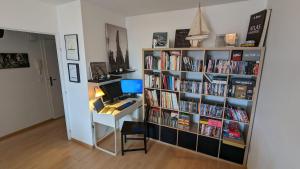 a room with a desk and a book shelf filled with books at Paris'door Cozy 2P 50m² all equipped in a village in Le Pré-Saint-Gervais