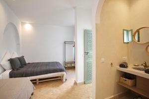 a bedroom with a bed and a bathroom with a mirror at Riad Amal, Exclusif et élégant à 6 min de Jemaa El Fna in Marrakesh