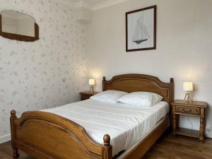 a bedroom with a wooden bed and two night tables at 801 - Maison 4 couchages, à deux pas du centre d'Erquy in Erquy