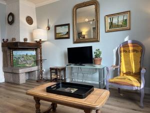 a living room with a tv and a table with a table sidx sidx at 801 - Maison 4 couchages, à deux pas du centre d'Erquy in Erquy +18 photos