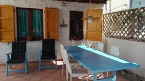 uma mesa azul e cadeiras num pátio em Casa Fiori Sa Marigosa em Putzu Idu
