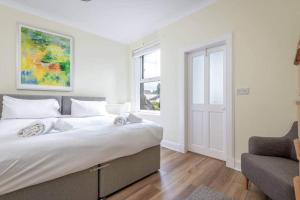 a bedroom with a bed and a couch and a window at 44 Argyle Street - 2 Bed-1 Bath - Central in St. Andrews