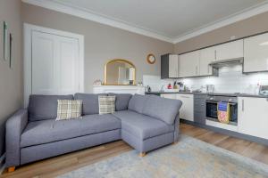a living room with a couch and a kitchen at 44 Argyle Street - 2 Bed-1 Bath - Central in St. Andrews