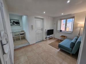 a living room with a blue couch and a television at Terrazza Ballarò in Palermo