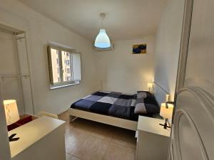 a bedroom with a bed and two white tables at Terrazza Ballarò in Palermo