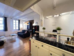 eine Küche und ein Wohnzimmer mit einem Sofa und einem Tisch in der Unterkunft Le Vogue - 4-6p - hypercentre-metro in Toulouse