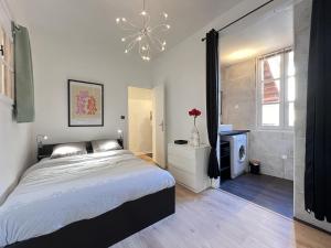 ein Schlafzimmer mit einem großen Bett und einem Kronleuchter in der Unterkunft Le Vogue - 4-6p - hypercentre-metro in Toulouse