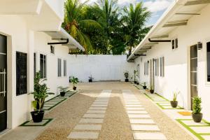 an empty courtyard of a white building with potted plants at Casa valencia 3 in Santa Elena