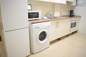 uma cozinha com uma máquina de lavar roupa e um micro-ondas em Apartamento LiLi Beach em Candelaria
