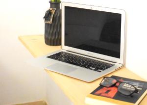 un ordenador portátil sobre una mesa de madera en Apartamento LiLi Beach, en Candelaria