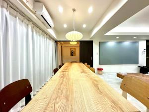 LoveTokyo Maisonette Terrace في طوكيو: قاعة اجتماعات مع طاولة طويلة وشاشة عرض