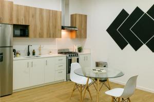 a kitchen with a glass table and white chairs at Casa valencia 3 in Santa Elena