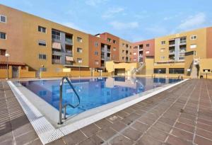uma piscina em frente a alguns edifícios de apartamentos em Apartamento LiLi Beach em Candelaria